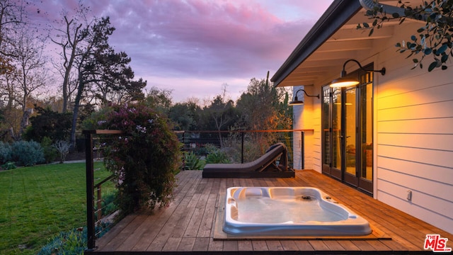 deck at dusk featuring a yard