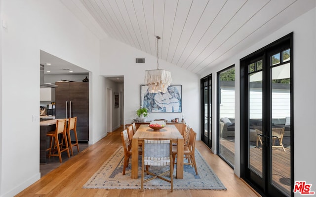 dining space featuring vaulted ceiling, an inviting chandelier, wood ceiling, and light hardwood / wood-style flooring