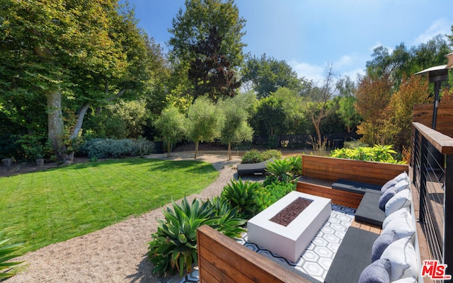 view of patio with an outdoor living space with a fire pit