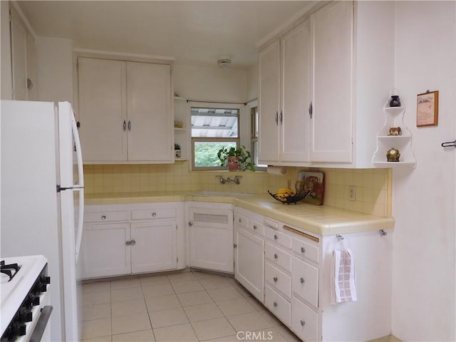 kitchen featuring tile countertops, white appliances, white cabinets, sink, and tasteful backsplash