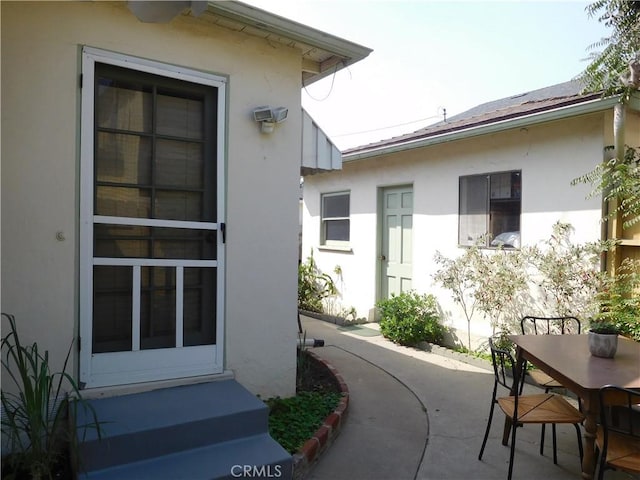 view of exterior entry featuring a patio area