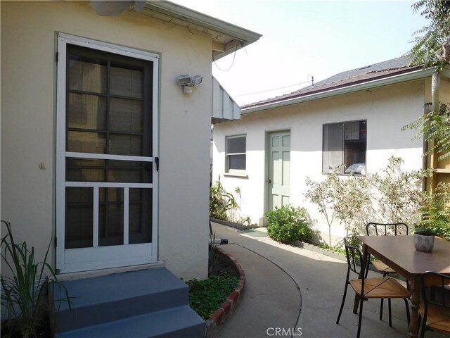 1415 Ximeno Ave, Long Beach, CA 90804 - view of exterior entry with stucco siding, outdoor dining space, and a patio area