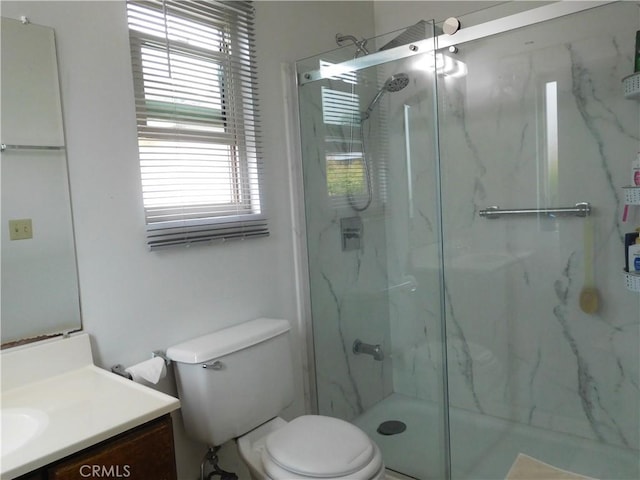 bathroom featuring vanity, toilet, and walk in shower