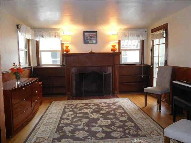 living area with plenty of natural light, light wood-type flooring, and a fireplace