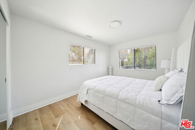 bedroom featuring light hardwood / wood-style floors and multiple windows