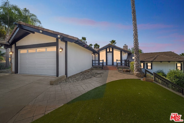 view of front of property featuring a garage and a lawn