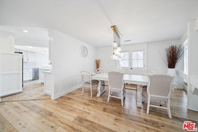 dining space featuring wine cooler and light hardwood / wood-style floors