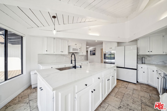 kitchen with white cabinets, a center island with sink, sink, and white appliances