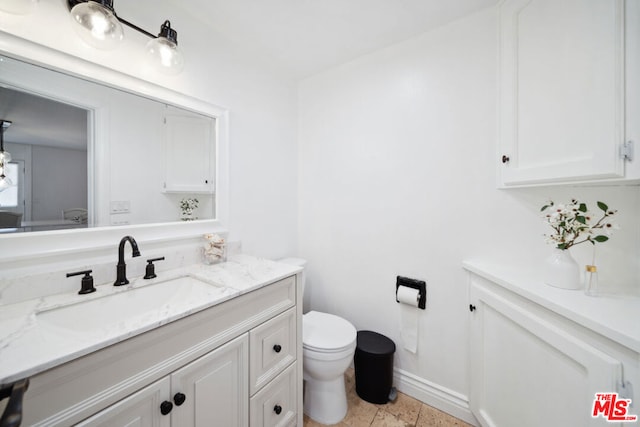 bathroom with vanity, toilet, and tile patterned floors