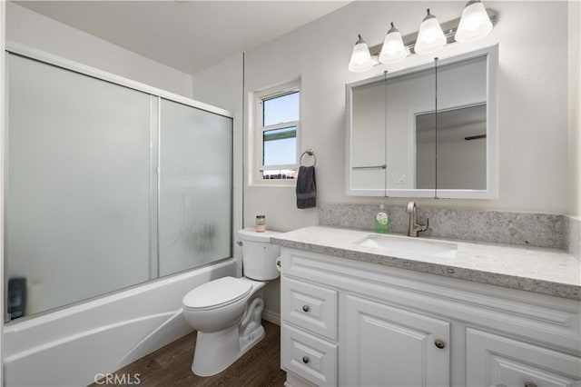 full bathroom with vanity, toilet, hardwood / wood-style flooring, and enclosed tub / shower combo