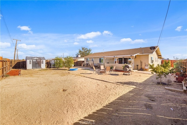 rear view of property featuring a patio and a storage unit