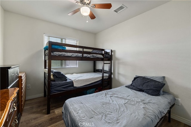 bedroom with dark hardwood / wood-style flooring and ceiling fan