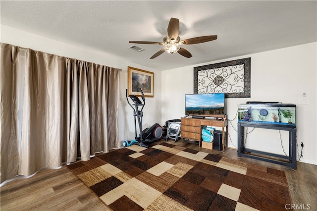 interior space featuring dark wood-type flooring, a textured ceiling, and ceiling fan