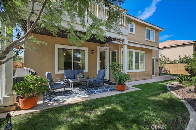 back of house featuring a lawn, fence, a patio, an outdoor hangout area, and stucco siding