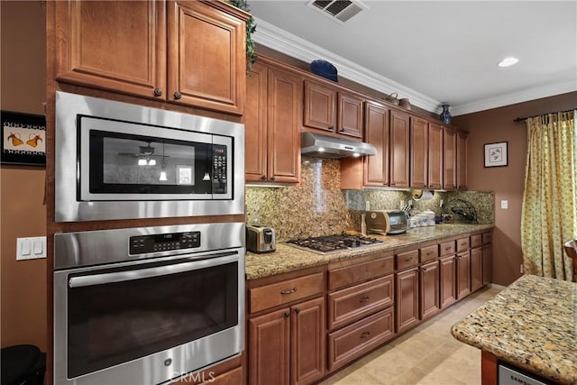 kitchen with crown molding, decorative backsplash, appliances with stainless steel finishes, under cabinet range hood, and visible vents