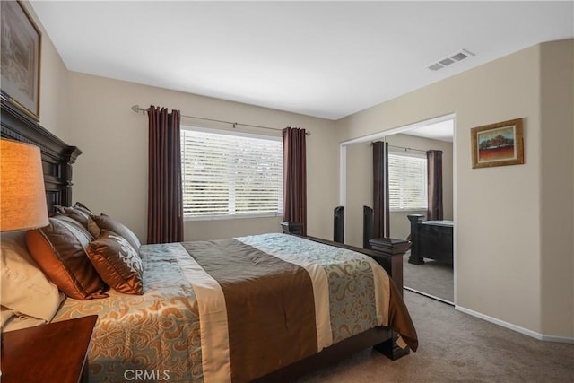 carpeted bedroom featuring a closet, visible vents, and baseboards