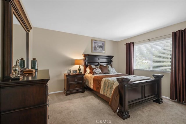 bedroom featuring light carpet and baseboards