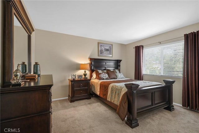 bedroom featuring baseboards and light colored carpet