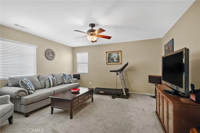 living area featuring a ceiling fan, light colored carpet, and visible vents