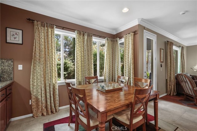 dining area featuring light tile patterned floors, ornamental molding, and baseboards