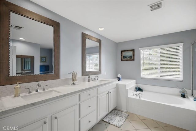 bathroom featuring a healthy amount of sunlight, visible vents, a sink, and a bath