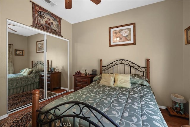 bedroom with a closet, visible vents, ceiling fan, wood finished floors, and baseboards