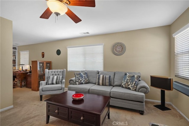 living area featuring a ceiling fan, light carpet, and baseboards