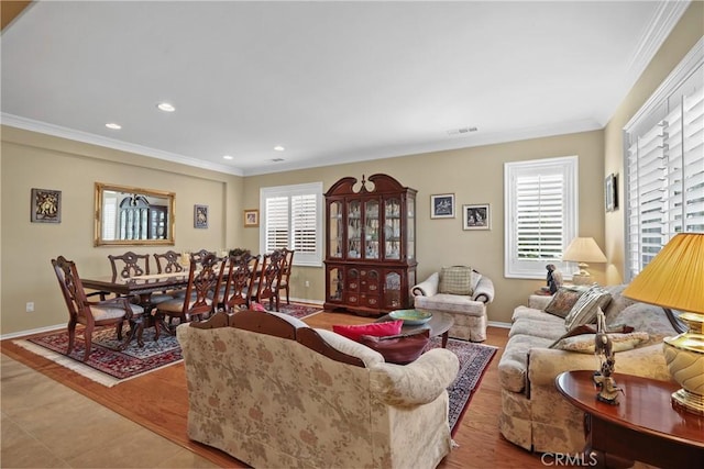 living area with baseboards, plenty of natural light, and crown molding