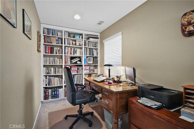 carpeted office space with built in shelves and visible vents