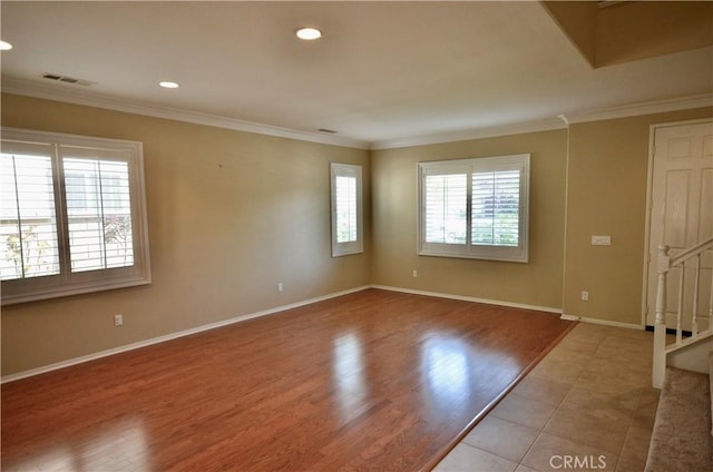 spare room with visible vents, crown molding, and baseboards