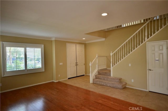 interior space with crown molding, wood finished floors, stairs, baseboards, and recessed lighting