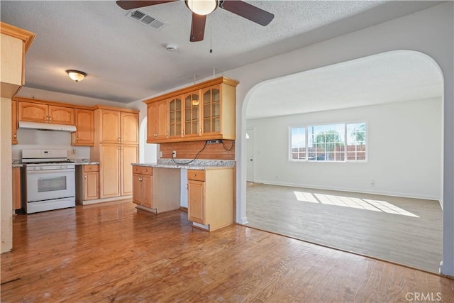 kitchen with ceiling fan, hardwood / wood-style floors, a textured ceiling, light brown cabinetry, and white range oven