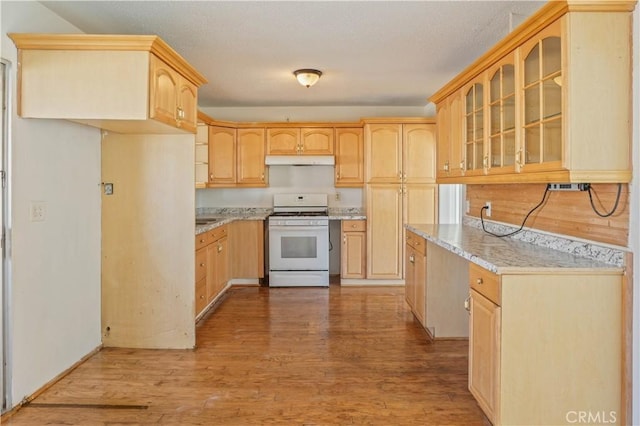 kitchen featuring light brown cabinetry, light stone countertops, white gas stove, and light wood-type flooring