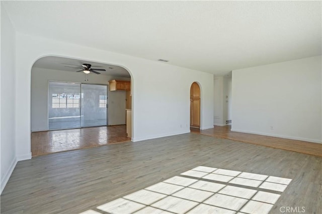 empty room with ceiling fan and light hardwood / wood-style floors