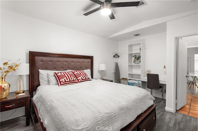 bedroom featuring dark hardwood / wood-style floors, built in desk, and ceiling fan