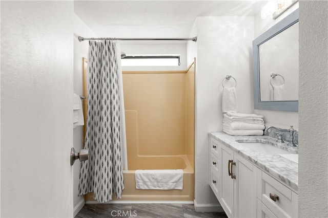 bathroom with vanity, a textured ceiling, shower / bath combination with curtain, and wood-type flooring