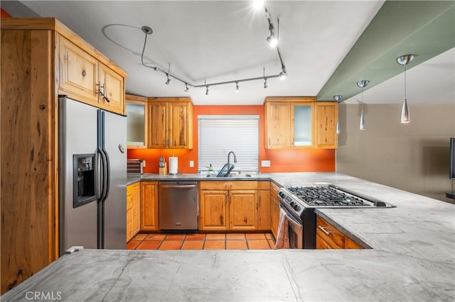 kitchen featuring kitchen peninsula, sink, decorative light fixtures, light tile patterned floors, and appliances with stainless steel finishes