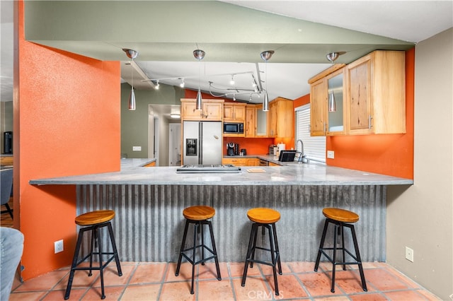 kitchen with a breakfast bar area, lofted ceiling, and stainless steel appliances