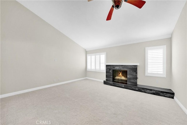 unfurnished living room with carpet, ceiling fan, lofted ceiling, and a tiled fireplace