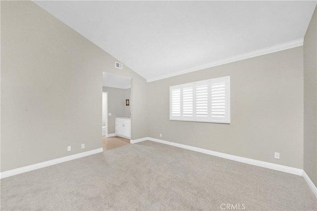 empty room featuring lofted ceiling and light carpet