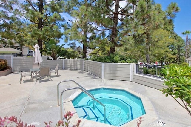 view of swimming pool featuring an in ground hot tub and a patio