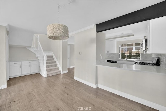 kitchen featuring white cabinets, range, decorative backsplash, and light hardwood / wood-style flooring