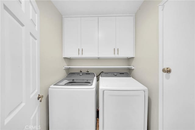 laundry area with cabinets and washing machine and clothes dryer