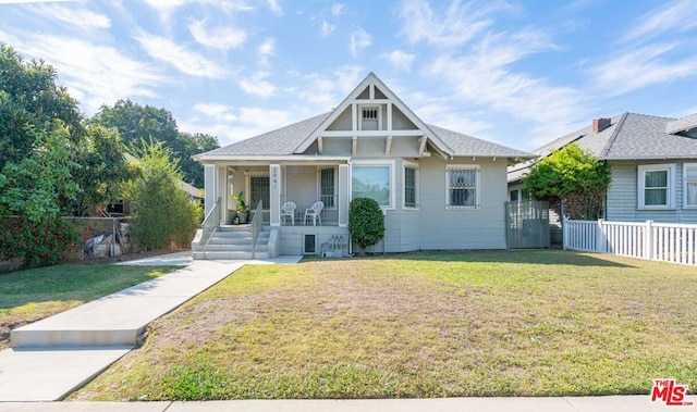 view of front of property featuring covered porch and a front yard