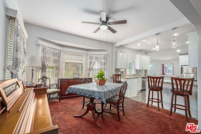 carpeted dining area featuring ceiling fan