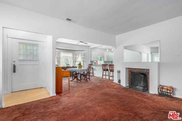 carpeted living room with ceiling fan