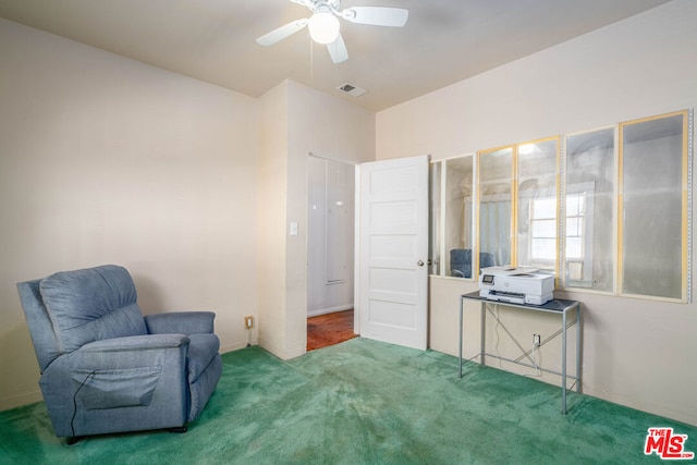 living area featuring carpet flooring and ceiling fan