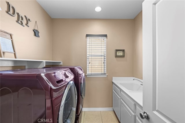 laundry area with light tile patterned floors, sink, washer and dryer, and cabinets