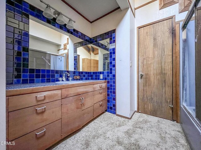 bathroom with vanity, ornamental molding, tile walls, and tasteful backsplash