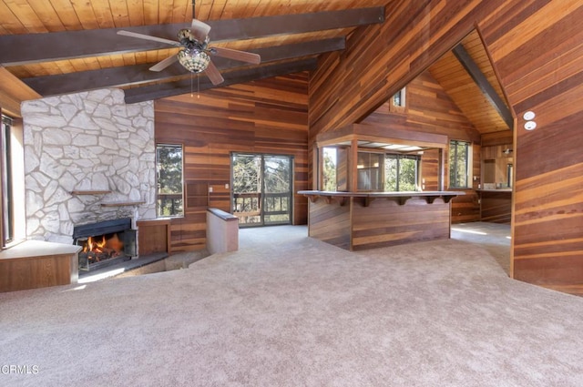 unfurnished living room with wood walls, light colored carpet, wood ceiling, and high vaulted ceiling